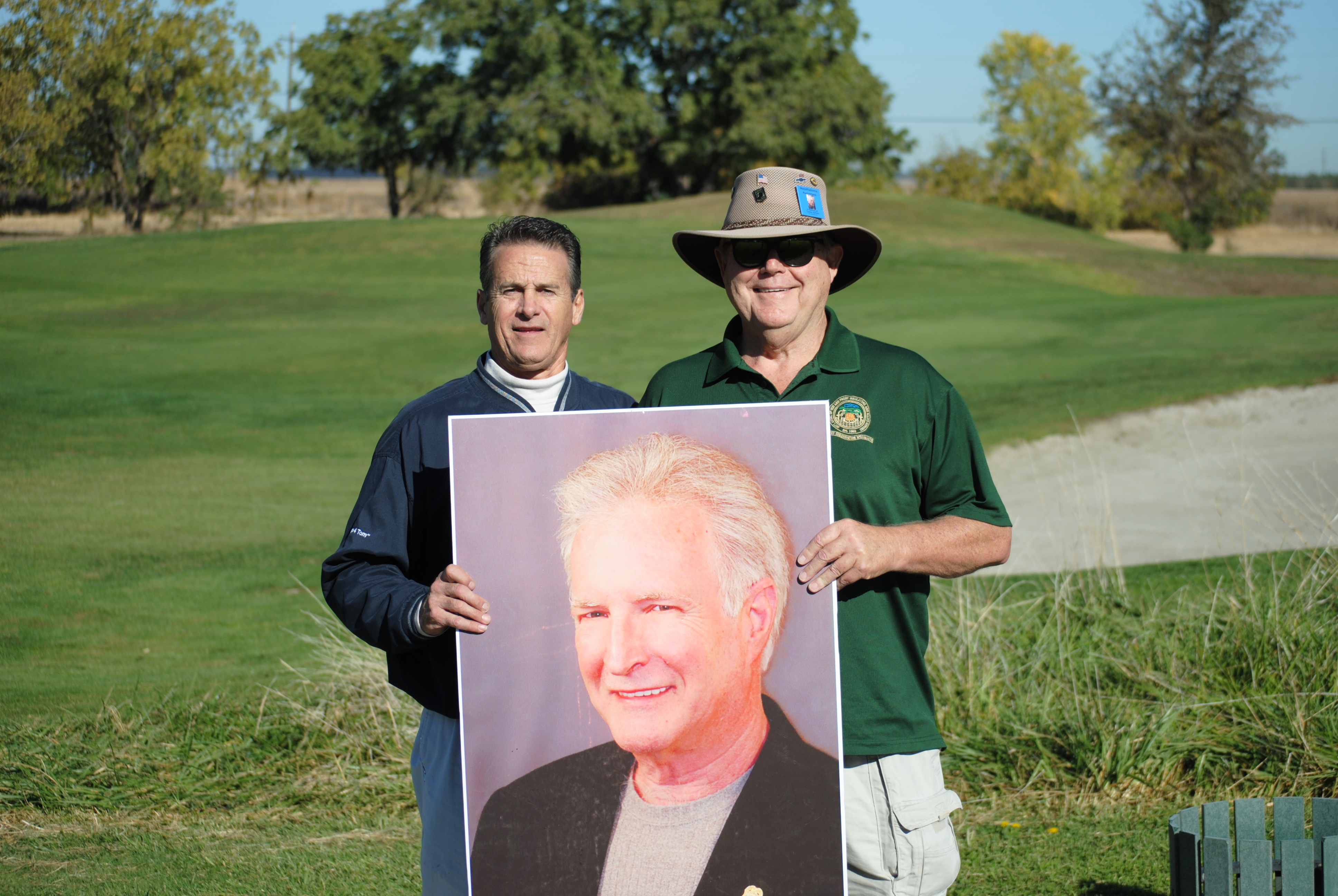 Greg Larkins and Geoff Millar of Asbestos Workers Local 16 pose with a photo of Tom Lawson during this year’s annual golf tournament.